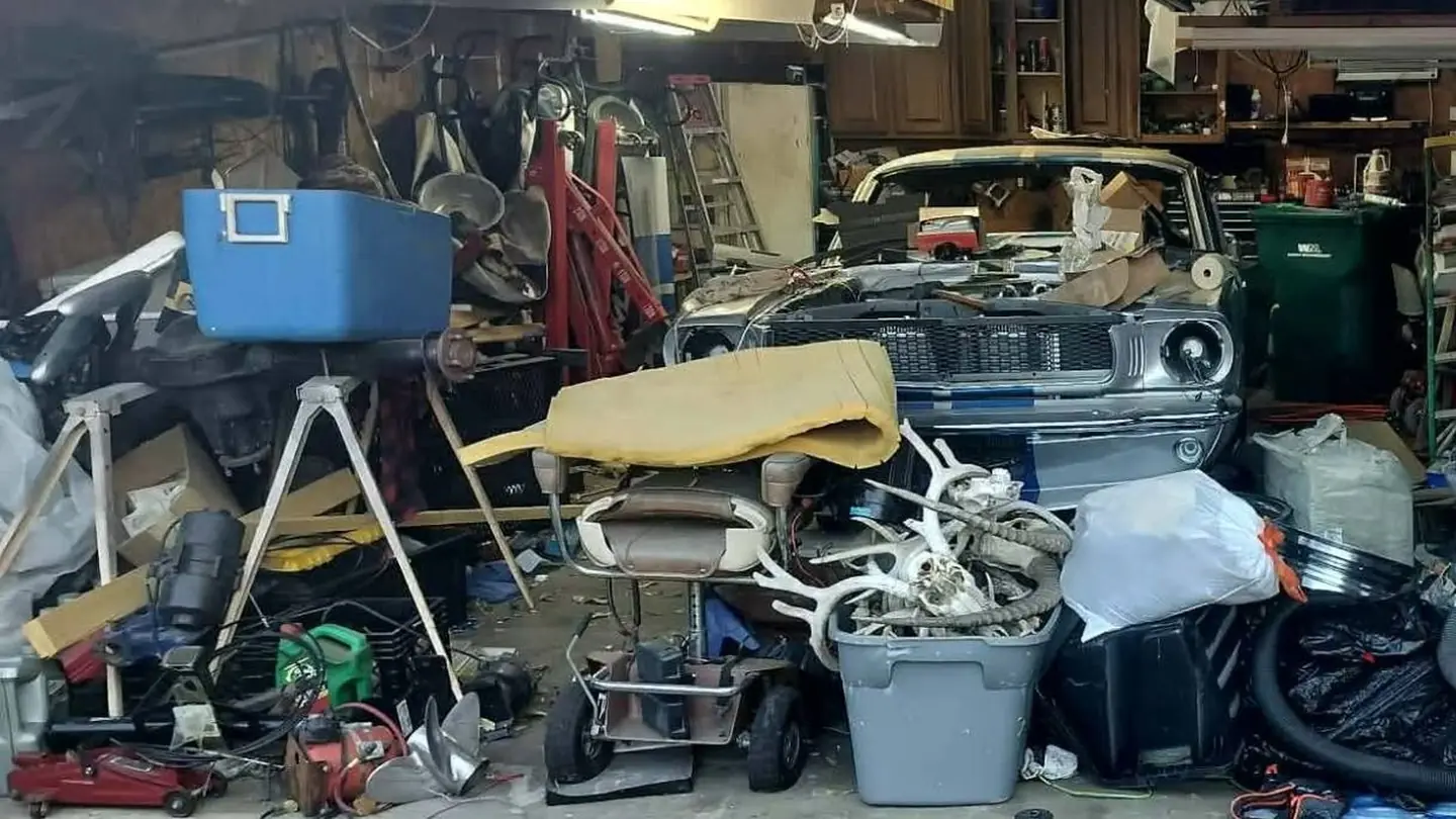 Before: a two-car garage packed with junk, furniture and equipment around a classic car