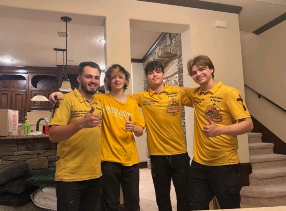 The Gabe's Faith crew in their yellow work shirts, giving a thumbs up